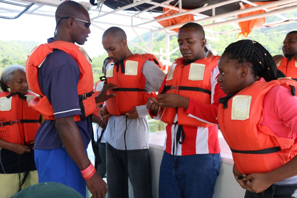 Mr. Archer guiding students on safety of a life jacket